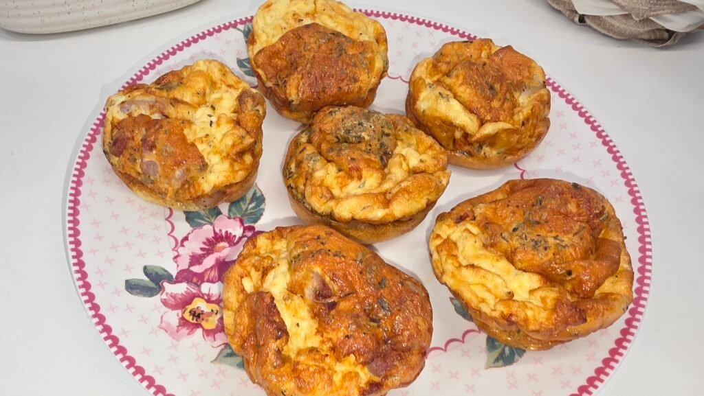6 mini quiches sans pâte posées sur une assiette aux couleurs printanière rose pale, réalisées à l'airfryer en quelque minutes