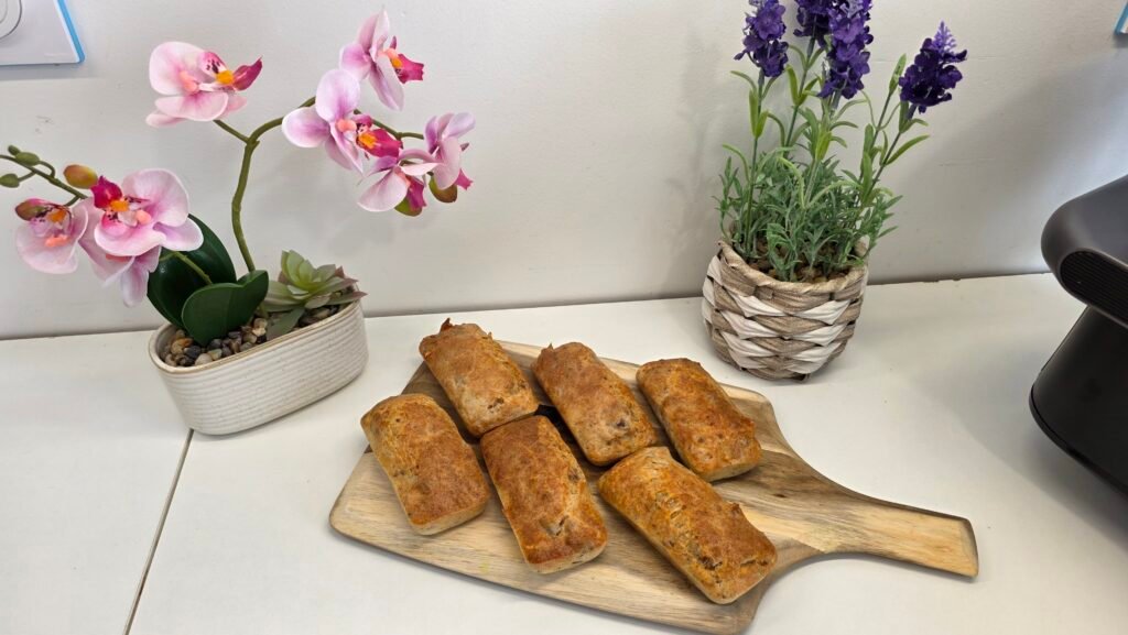6 mini cakes au thon posés sur une planche en bois avec quelques brins de ciboulettes réalisés à l'airfryer