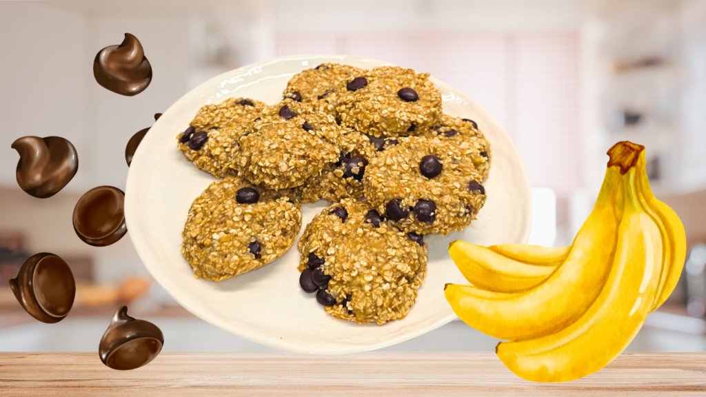 Gros plan : assiette blanche remplie de 6 cookies bananes, flocon d'avoine et pépites de chocolat , à gauche pépites de chocolat qui tombent et à droite une grappe de 4 bananes en fond une cuisine floutée lumineuse.