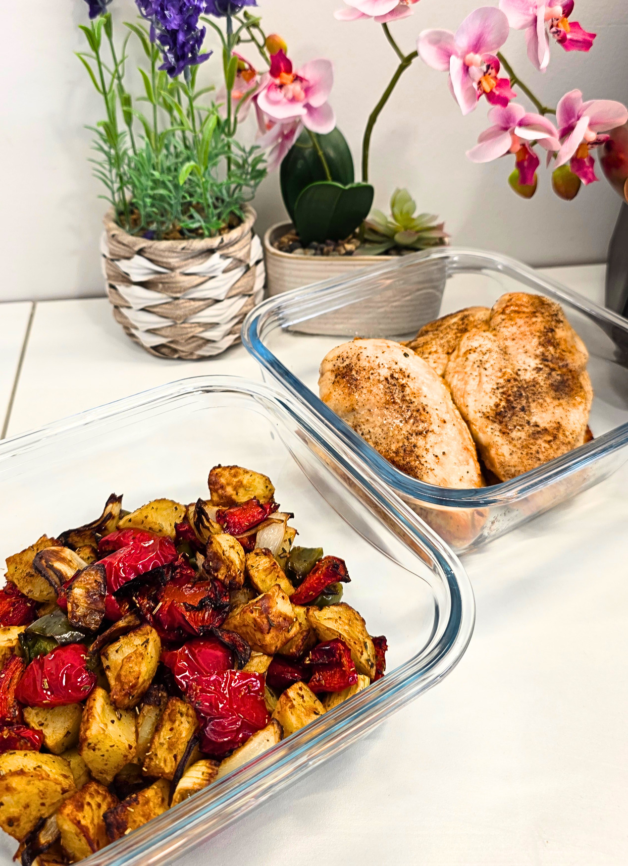 Poulet et légumes rôtis à l'airfryer sur un plan de travail dans deux plats en verre carré